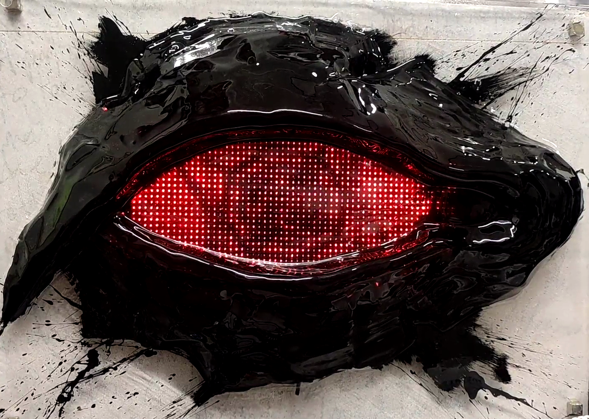 Close-up of the AILA LED eye peripheral — red LED matrix embedded in hand-painted sculptural surround