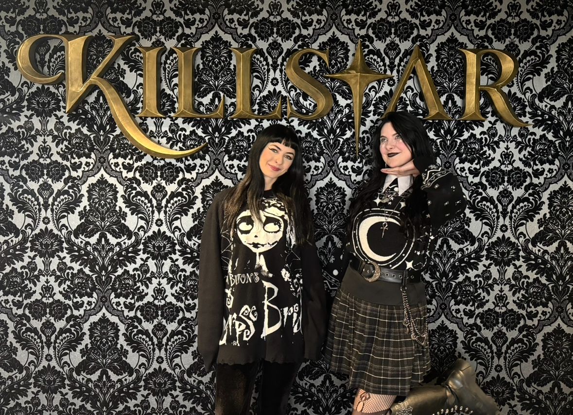 Two people standing in front of the installed Killstar sign in the finished office environment