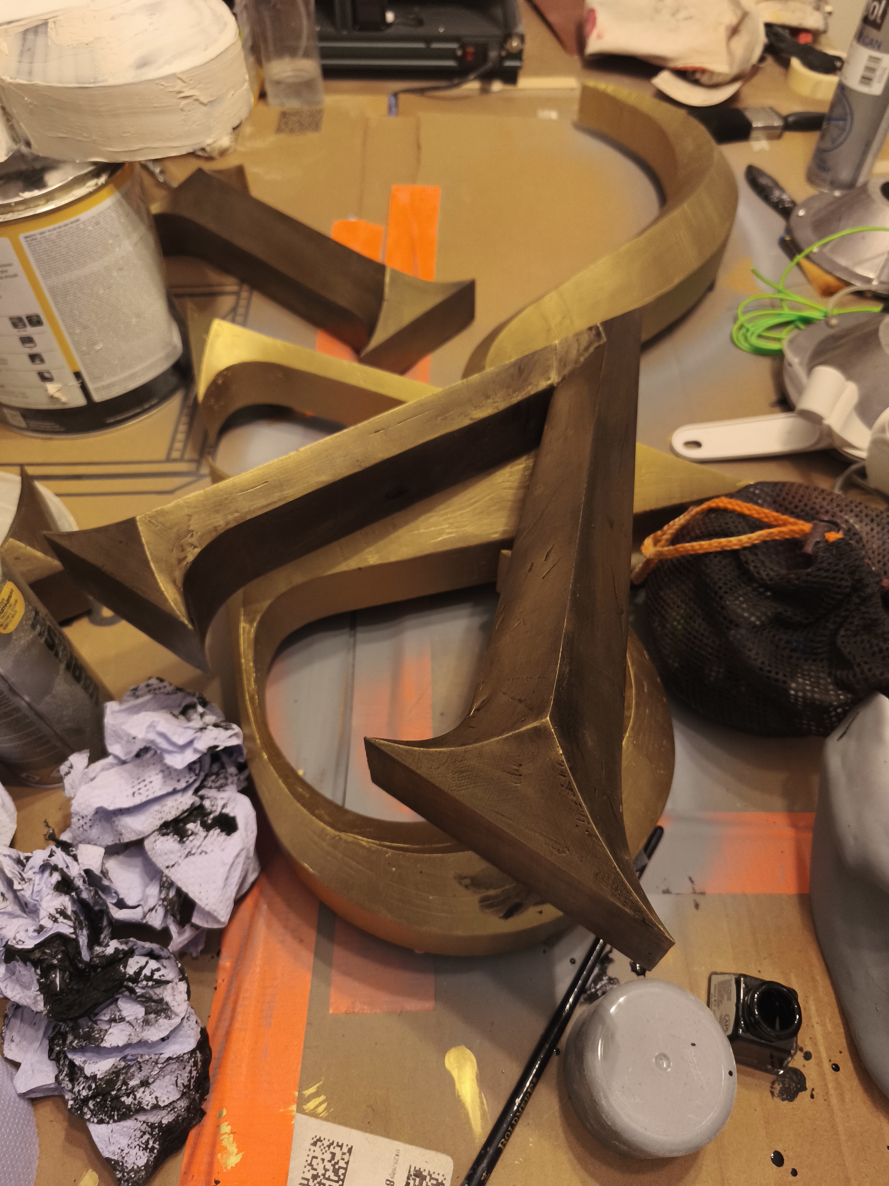 Killstar signage letters mid-finishing process on workbench, gold paint stage