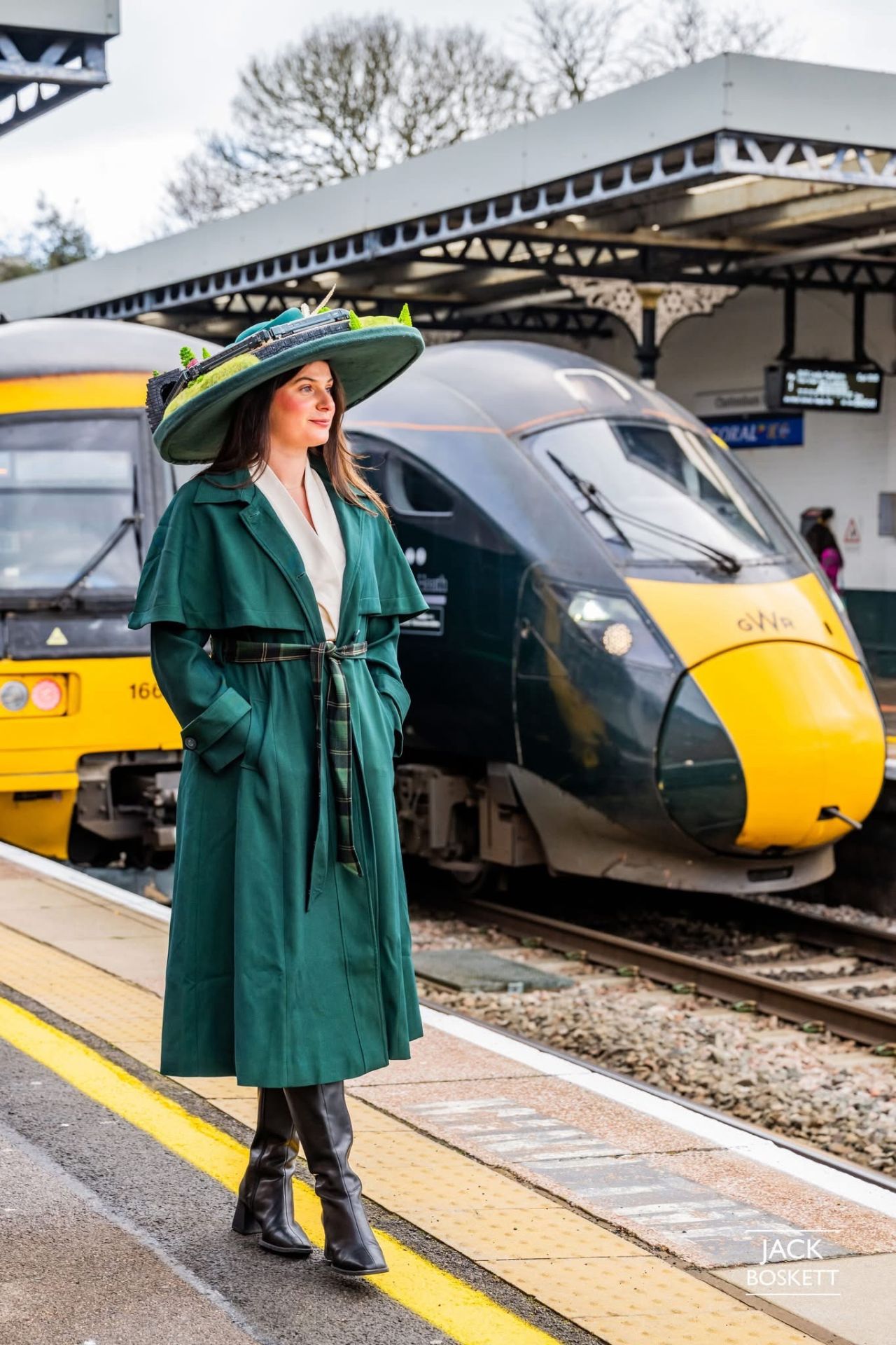 Full outfit at a railway platform, GWR train visible behind — hat colour-matched to coat and accessories