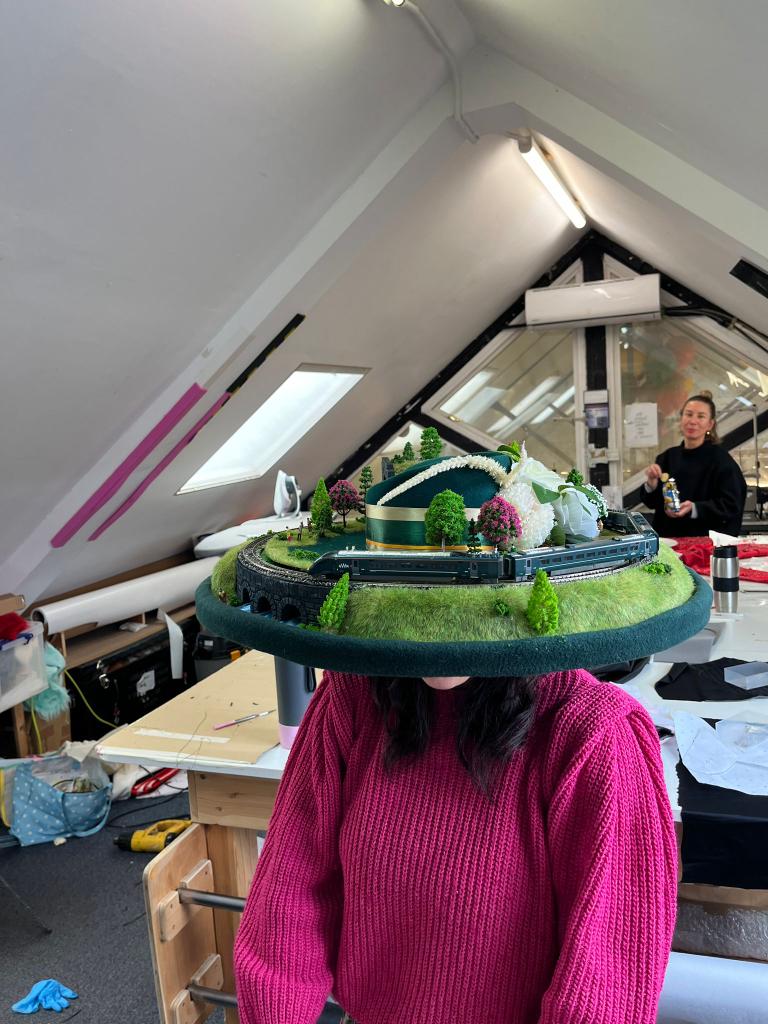 Train Hat in the studio during build — track, terrain and tunnel structure visible on the hat brim